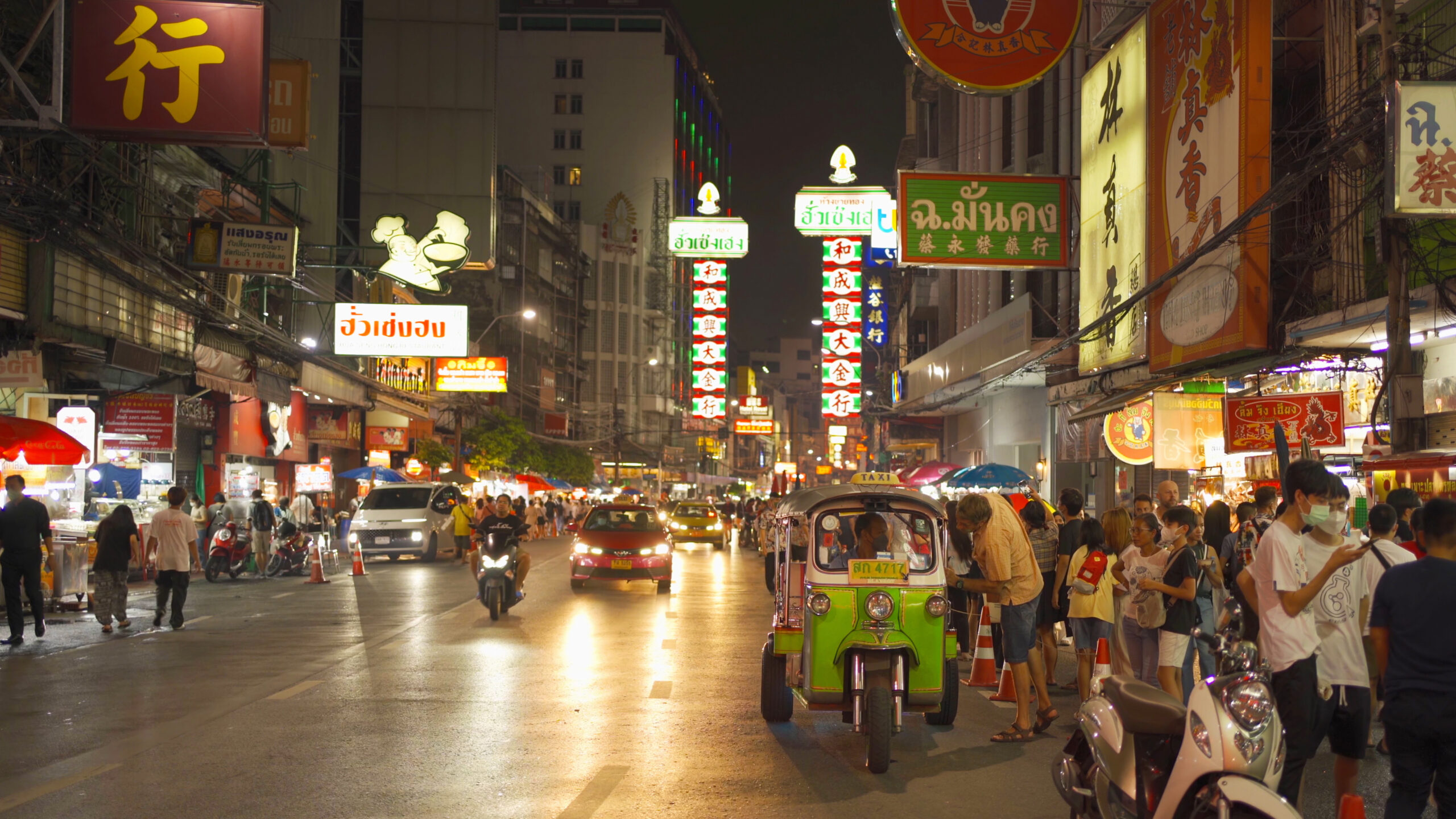 Night market at Yaowarat road, Bangkok City, Thailand. The famous tourist attraction with full of advertising Chinese signs. Cars of tourists people with billboard. China town. Walking street. night scene in bangkok, thailand for digital nomads
