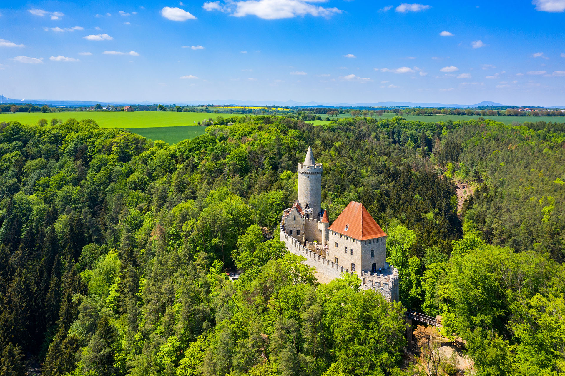 medieval castle Kokorin surrounding by green trees near prague