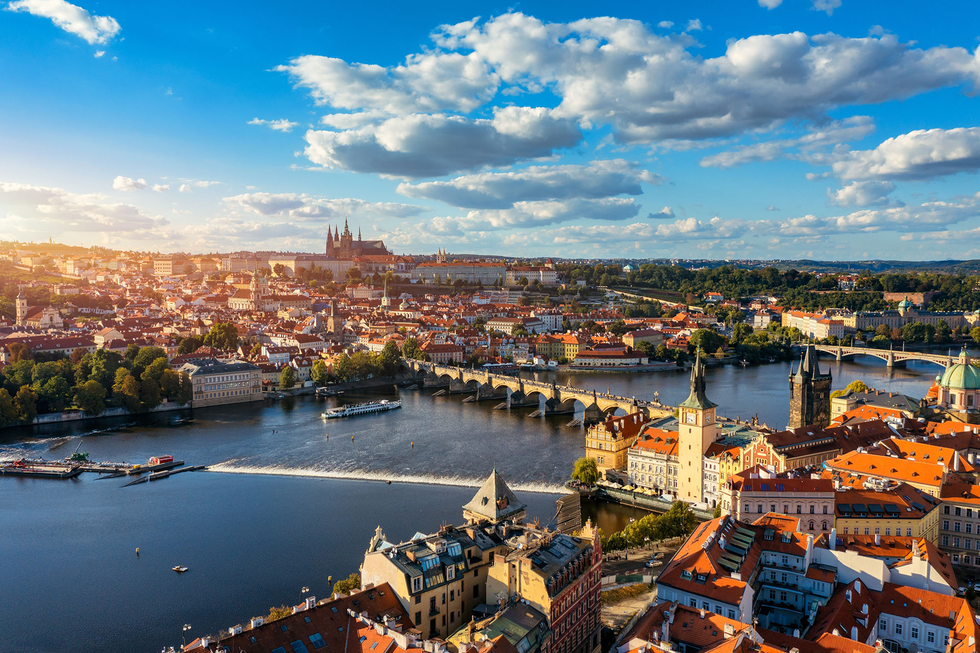 aerial view of bridge to old town prague with cloudy sky and river