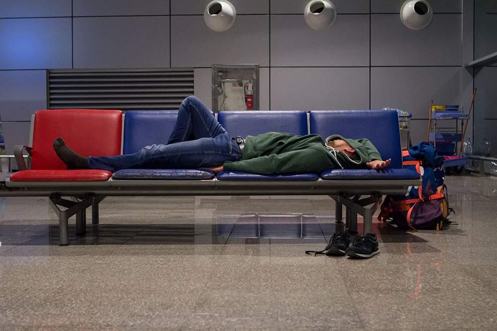 young tourist man with a backpack is sleeping in a airport waiti sleeping airport terminal